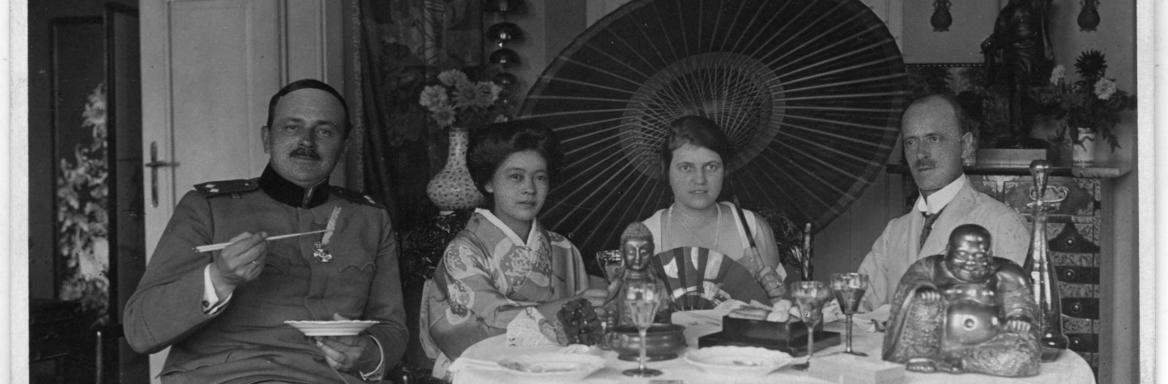 Zakonca Skušek in njuna obiskovalca v dnevni sobi, natrpani s pohištvom in predmeti iz zbirke, dvajseta leta 20. stoletja. Foto: Dokumentacija SEM.