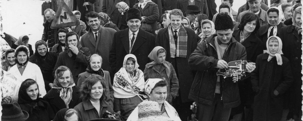 Boris Kuhar s kamero in fotoaparatom med udeleženci borovega gostüvanja. Šalovci, 1964 (dokumentacija SEM).