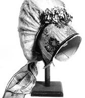 Ženitovanjska avba z brokatnim čelnikom, cvetličnimi okraski, krožnikastim oglavjem in pentljo / neznane provenience / iz zbirke SEM / foto: J. Žagar. 