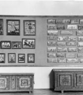 Utrinek iz stalne postavitve Etnografskega muzeja na Prešernovi. Dvorana slovenske ljudske umetnosti (zgoraj slike na steklu in panjske končnice, spodaj dve poslikani skrinji).