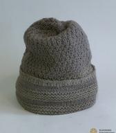 Ženska zimska kapa, ročno pletena iz sive domače volne, z glavi priležnim oglavjem in z zavihanim, na oglavje prišitim zavihkom / Loče pri Poljčanah / iz zbirke SEM / foto: J. Žagar. 