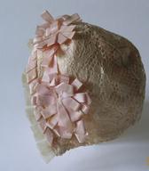 Krstna čepica za dojenčka iz svilene belkaste strojne čipke, podložene s tanko roza svilo. Čepica iz leta 1906 je bila del krstne opreme za prvorojenko v družini poštnega uradnika / Novo mesto / iz zbirke SEM / foto: J. Žagar. 