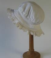 Ženska spalna čepica iz belega bombaža, z okroglim oglavjem in naborkom. Čepica je bila izdelana leta 1894 za balo hčere kmečkega posestnika, mesarja in gostilničarja / Vojnik pri Celju / iz zbirke SEM / foto: J. Žagar. 