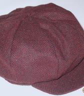 Dekliška kapa s ščitnikom iz rjavo-črnega volnenega blaga, z mehkim oglavjem in s trdim polkrožnim ščitnikom iz enakega blaga. Kapa je bila izdelana in kupljena v Italiji, kot zaščito pred mrazom jo je sredi 90. let uporabljala ljubljanska gimnazijka / Ljubljana / iz zbirke SEM / foto: J. Žagar. 