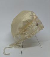 Ženska spalna čepica iz tanke krem svile. Pred 2. svetovno vojno jo je uporabljala slovenska izseljenka v Ameriki, žena lastnika radijske postaje. Kasneje je bila čepica spominski predmet na pokojno sorodnico / Millwaukee, ZDA / iz zbirke SEM / foto: J. Žagar. 