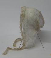 Ženska čepica iz belega bombažnega tila, z našitimi trakovi belih strojnih čipk in svile / Ptuj in okolica Ptuja / iz zbirke SEM / foto: J. Žagar. 