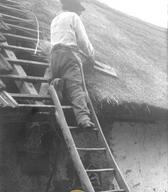 Krovec pri delu oblečen v srajco – robačo iz domačega platna, foto Fran Vesel, Preloka, 1920 (Dokumentacija SEM). 