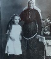 Birmanka z venčkom in botra s pečo, zavezano »na petelina«, Bizovik pri Ljubljani, 1920 / Dokumentacija SEM. 