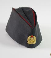 Mehka kapa z zlatim grbom gasilcev, del svečane uniforme poklicnega gasilca, vodje gasilske enote od 60. let 20. stol. / Cerknica  / iz zbirke SEM / foto: J. Žagar. 