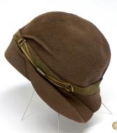 Ženski klobuk iz rjave kosmatene klobučevine z okroglim priležnim oglavjem in posebej krojenim čelnim zavihkom; iz delavnice modistke M. Sark / Ljubljana /  iz zbirke SEM / foto: J. Žagar. 