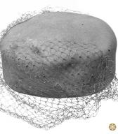 Ženski klobuček iz umazano bele klobučevine, z ravnim oglavjem in ravnim vrhom, brez krajcev. Pokrivalo je uporabljala žena učitelja / Zalog pri Ljubljani / iz zbirke SEM / foto: J. Žagar. 