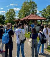 Skupina dijakov iz Dvojezične srednje šole Lendava se z Aljažem Planklom spoznava s principi trajnostnega vrtnarjenja. Lendava, 24. maj 2025. Foto: Sandi Horvat.